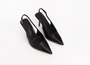 Pair of black pointed-toe slingback heels on a white background