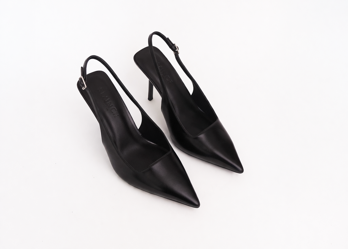Pair of black pointed-toe slingback heels on a white background