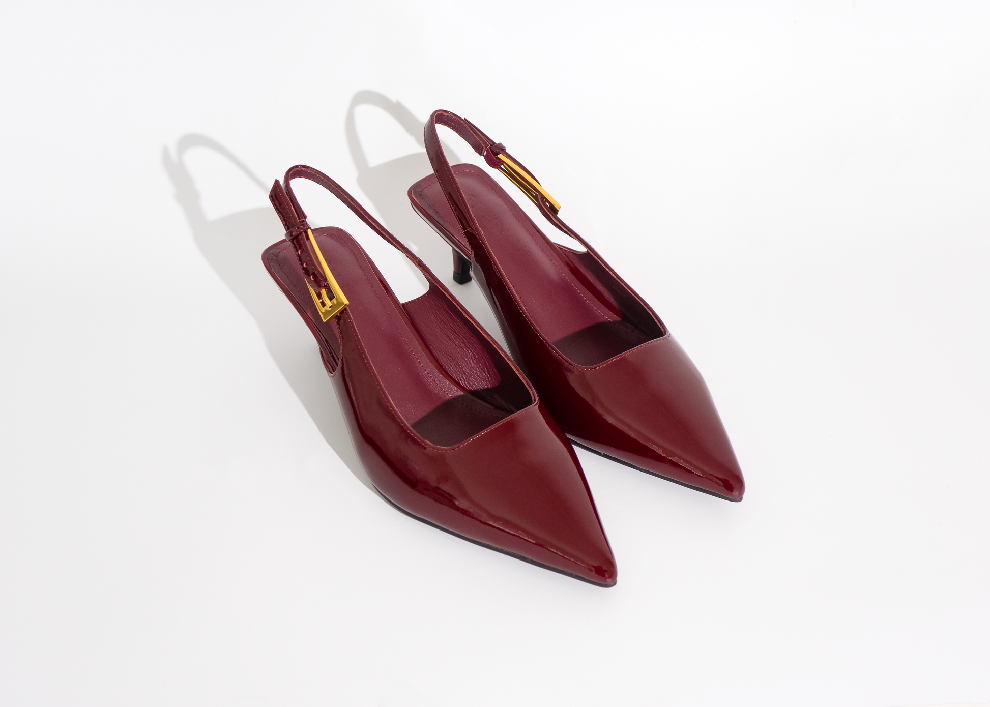 Pair of red slingback shoes on a white background