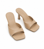 A pair of beige leather mule sandals with a square toe and a low block heel, shown on a clean white background.