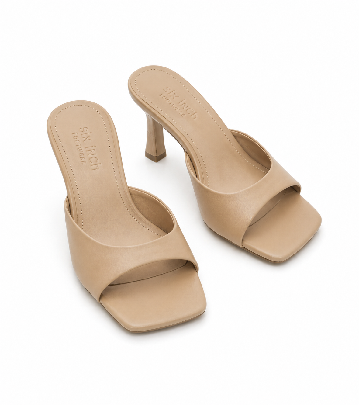 A pair of beige leather mule sandals with a square toe and a low block heel, shown on a clean white background.