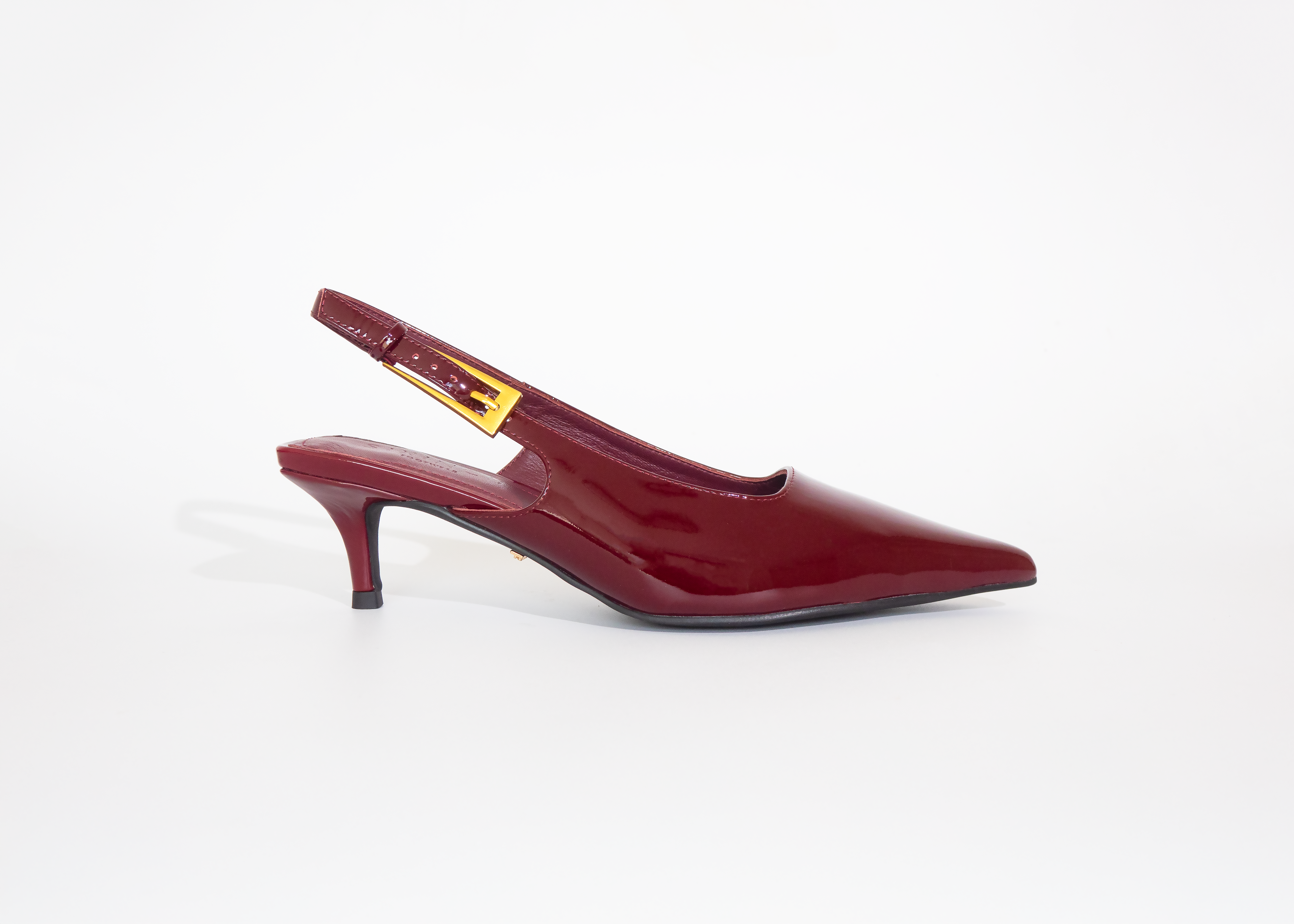 Red slingback shoe on a white background gold buckle detail