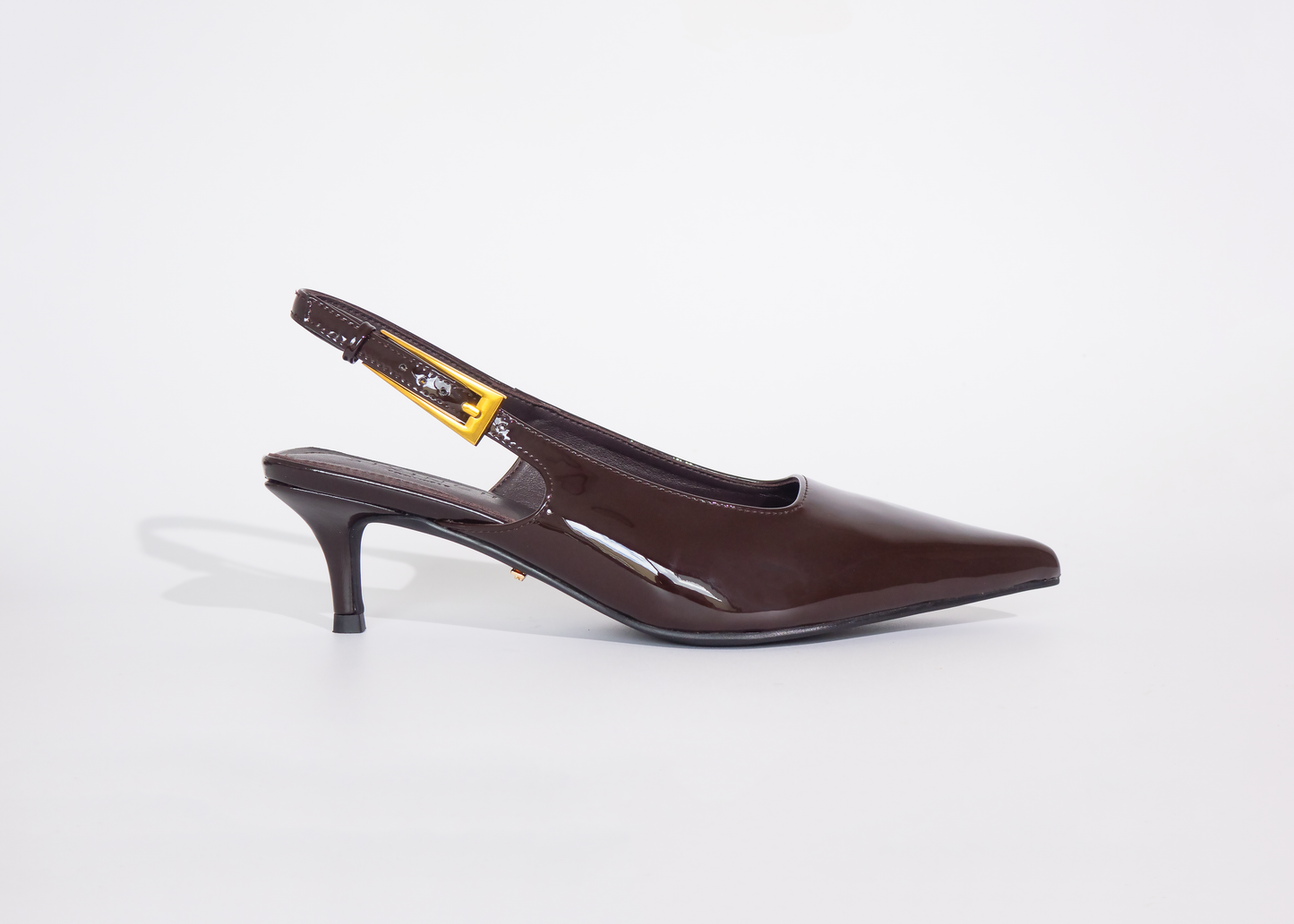 Brown wide fit high-heeled shoe on a white background with kitten heels and gold buckle strap
