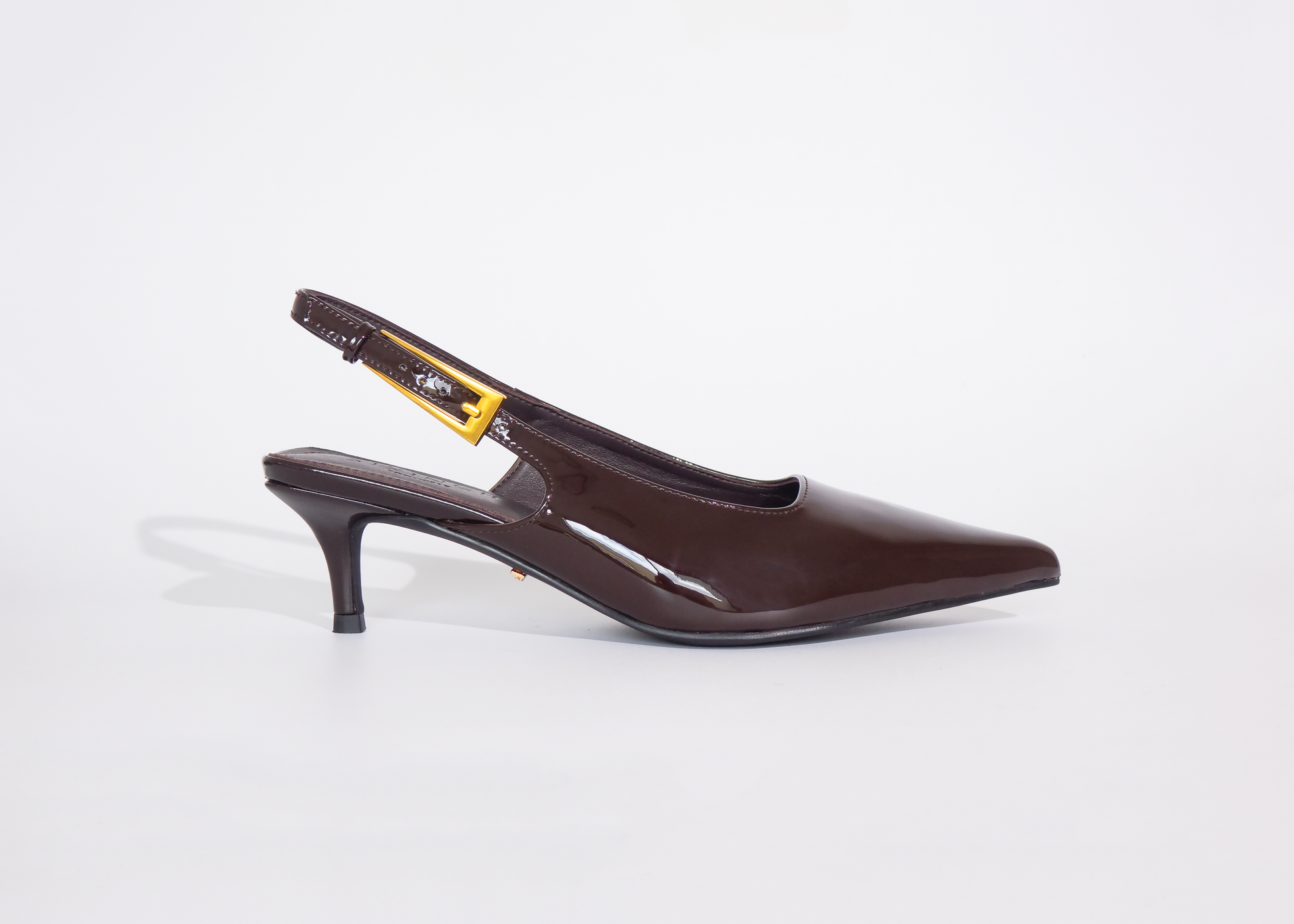 Brown wide fit high-heeled shoe on a white background with kitten heels and gold buckle strap